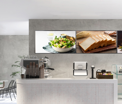 Two free-standing digital signage totems beside a mall escalator